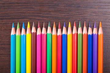 multicolored pencils on the brown wooden table