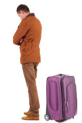 Back view of young man traveling with suitcas.