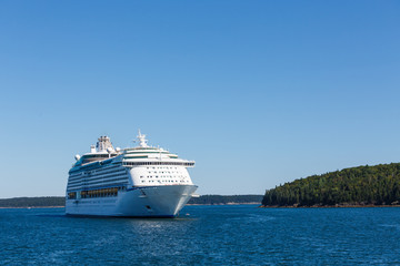 Fototapeta na wymiar White Cruise Ship Between Blue Sea and Blue Sky