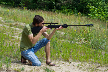 Young man taking aim with the air rifle