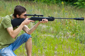 Young man taking aim with the air rifle