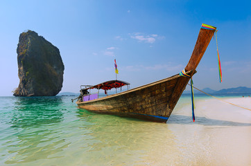 Thai longtail boat in shallow water on white beach
