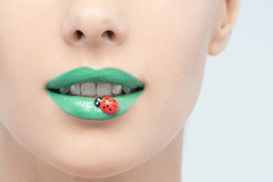 Closeup portrait of beautiful woman with green lipstick and deco