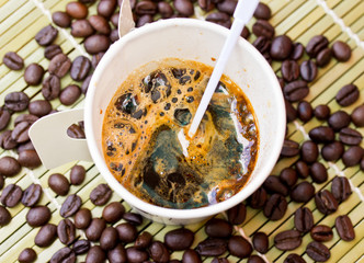 paper cup of black coffee and coffee bean on bamboo straw