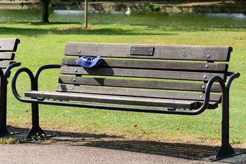 Lost hat in slats of park bench