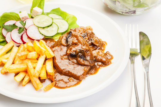 Pork chop with sauce, mushrooms and chips