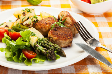 Meatballs served with boiled potatoes and asparagus