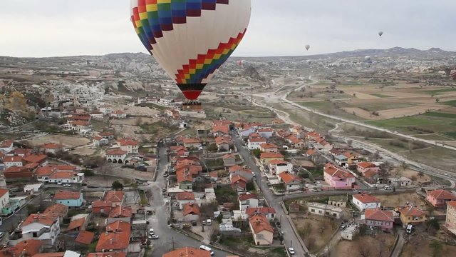 Colorful hot air balloon flying high over a city