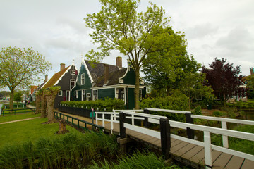 Fototapeta na wymiar rural dutch scenery of small old houses and canal in Zaanse, Net