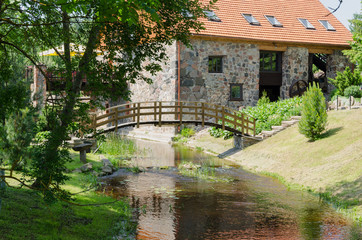 Fototapeta na wymiar park with bridge over stream ancient brick manor