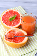 Ripe grapefruits on cutting board, on wooden background