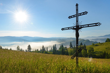 Fototapeta na wymiar Crucifixion of Jesus Christ in the midst of meadows in Carpathia