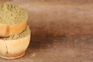 Dry henna powder in bowls on wooden table