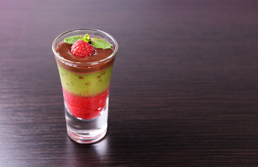 Glass of kiwi fruit and raspberry smoothies on table background