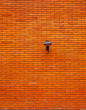 Lamp on orange brick wall © sakepaint