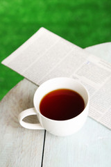 Cup of tea on wooden table, outdoors