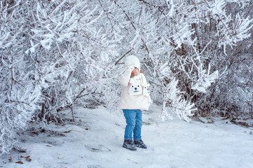 Child walking in winter forest