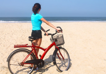 Fototapeta na wymiar beautiful girl on a bicycle on the beach