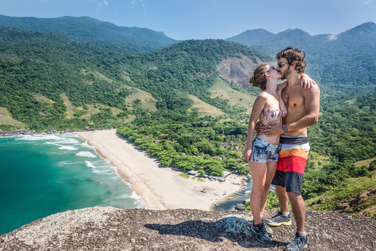 Beautiful couple kissing at a stone cliff, Brazil tropical islan