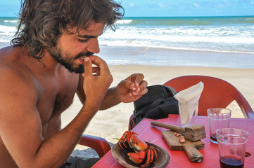 Argentinean Young Men eating Red Crab at Salvador Bahia, Brazil.