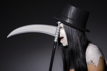 Woman in halloween concept with scythe