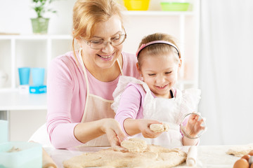 Obraz na płótnie Canvas Grandmother and granddaughter making Dough