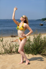 Dziewczyna, blondynka na plaży w stroju kąpielowym. - obrazy, fototapety, plakaty