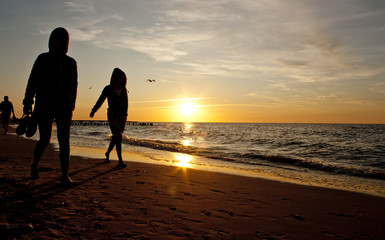 Friends walking on a beach during a sunset