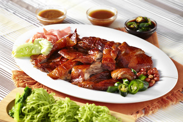 close up chinese roasted duck and green noodle in white dish