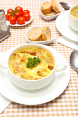 Tasty soup in saucepan on tablecloth, close up