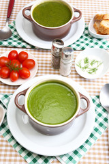 Tasty soup in saucepans on tablecloth, close up