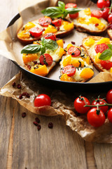 Fototapeta na wymiar Tasty bruschetta with tomatoes on pan, on old wooden table