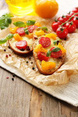 Tasty bruschetta with tomatoes, on old wooden table