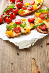 Tasty bruschetta with tomatoes, on old wooden table