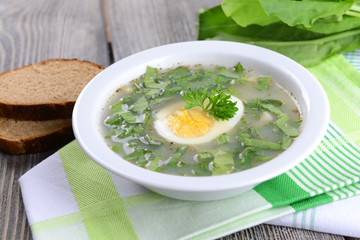 Delicious green soup with sorrel on table close-up