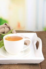 Tasty herbal tea with linden flowers on wooden table