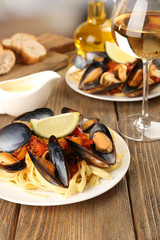 Tasty noodles with mussels on table, close up
