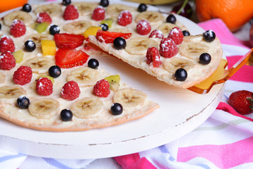 Sweet pizza with fruits on table close-up