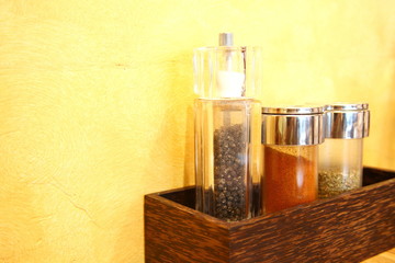 Pepper and salt bottle among the yellow wall