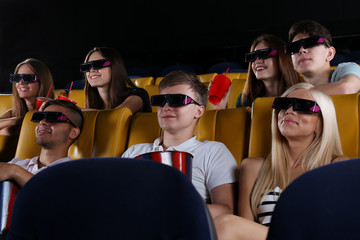 Obraz premium Young people watching movie in cinema