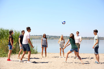 Group of friends playing volleyball at beach