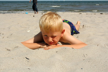 The boy lies on the sea beach