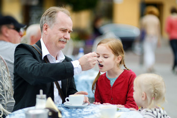 Grandfather feeding frothy milk to his grandchild