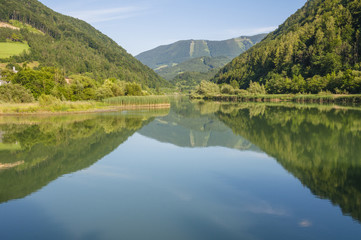 Fototapeta na wymiar Mountain mirroring in the river Enns in Upper Austria