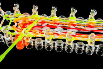 Rainbow loom toy with colorful rubber bands