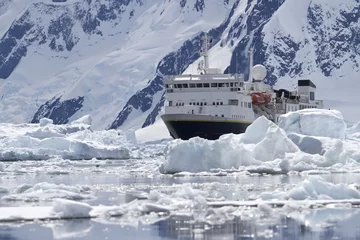Foto op Canvas groot blauw toeristenschip in het ijs op de achtergrond van de Antarc © Tarpan