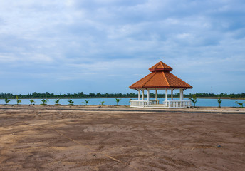 Pavilion on ground with lake and blue sky background