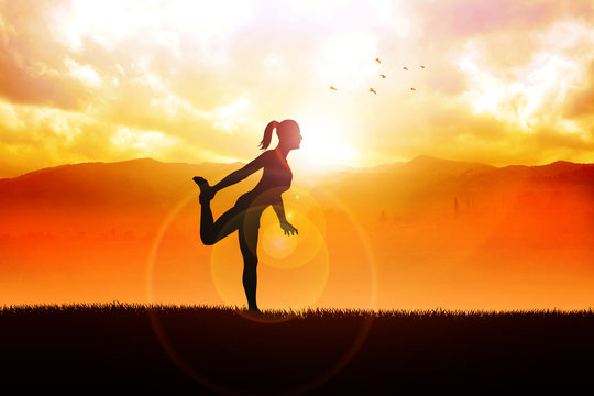 Silhouette of a woman stretching her leg during sunrise