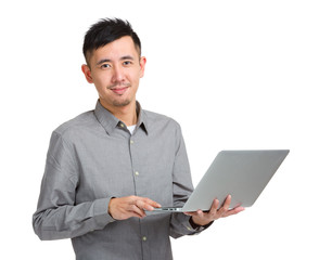 Asian man type on laptop computer