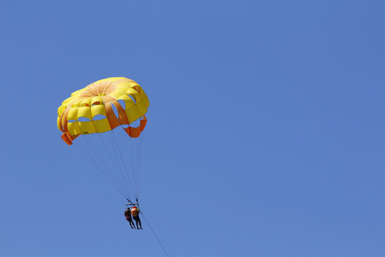 Parasailing against blue sky